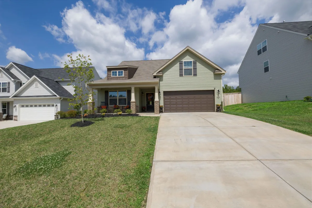 Newly poured concrete driveway running to an attached two-car garage on a suburban house